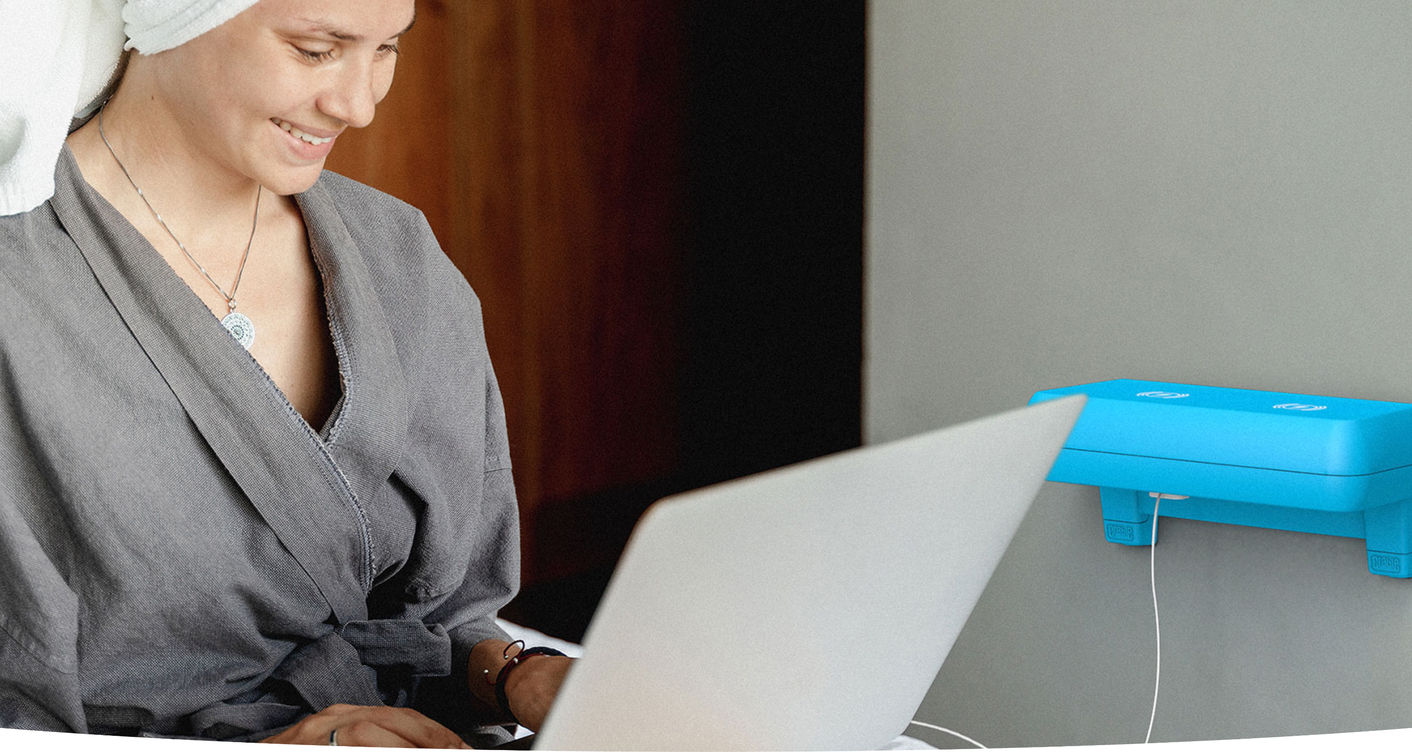 Crable shelving unit charging laptop as woman works in a cafe