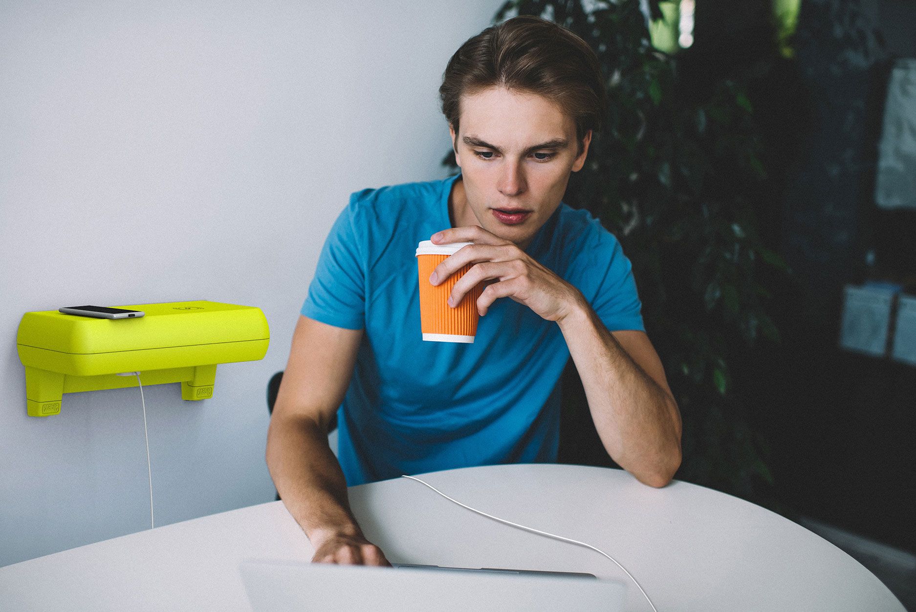 Crable shelving unit charging man's laptop as he works in a cafe